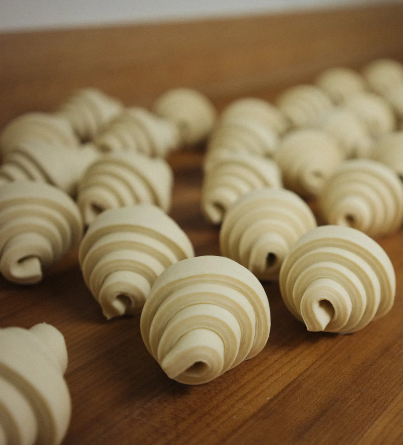 Croissants rolled and lined up on the bench