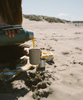 Pouring coffee from a thermos on the beach