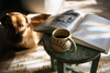 A mug of black coffee on a stool in the afternoon light