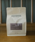 A bag of HoneyCo Classic Espresso on a wooden table