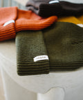 Woven Scout label on the cuff of the Scout Beanie in Gold, Brown, Rust and Green
